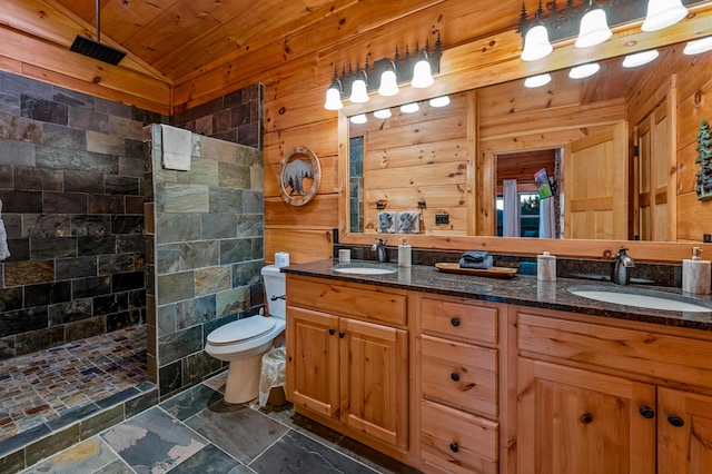 full bath featuring stone tile flooring, a walk in shower, and a sink