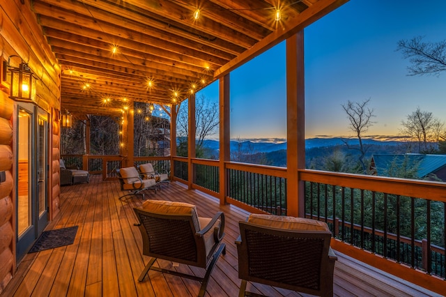 deck at dusk featuring a mountain view