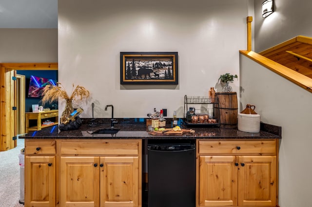 kitchen with carpet, a sink, and dark stone countertops