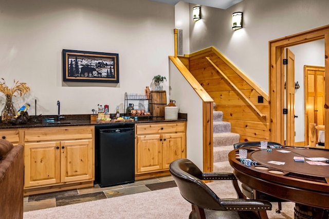 bar with stairs, indoor wet bar, a sink, and black dishwasher