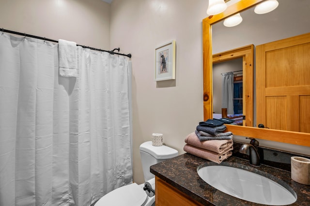 bathroom with toilet, a shower with shower curtain, and vanity