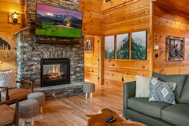 living room featuring wood walls, a fireplace, and wood finished floors