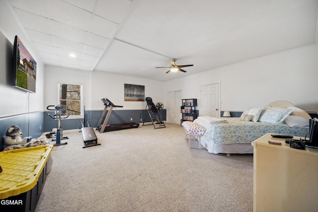 bedroom featuring a ceiling fan, carpet flooring, and a drop ceiling