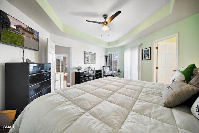 bedroom with a raised ceiling and ceiling fan