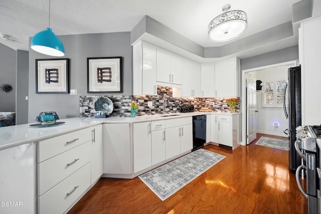 kitchen featuring stainless steel range with gas cooktop, light countertops, dishwasher, and wood finished floors