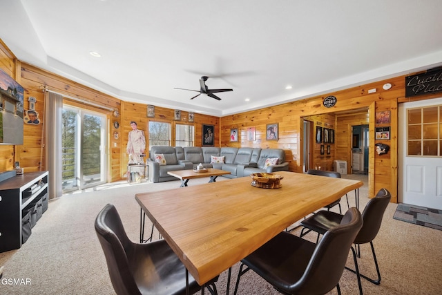 carpeted dining area featuring ceiling fan, wooden walls, and recessed lighting