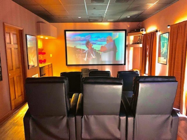 cinema featuring a drop ceiling and hardwood / wood-style flooring