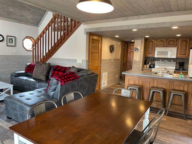 dining space with wood ceiling, wood walls, and light hardwood / wood-style floors