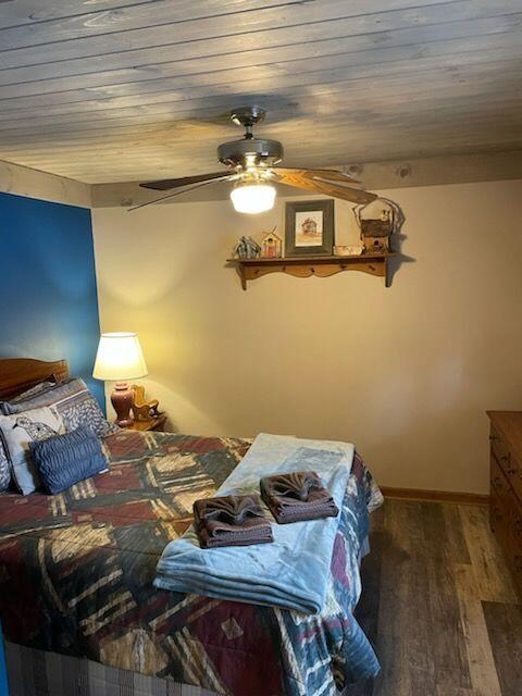 bedroom featuring hardwood / wood-style flooring, ceiling fan, and wood ceiling