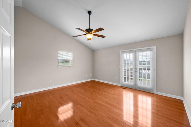 spare room featuring wood finished floors, a ceiling fan, visible vents, and vaulted ceiling