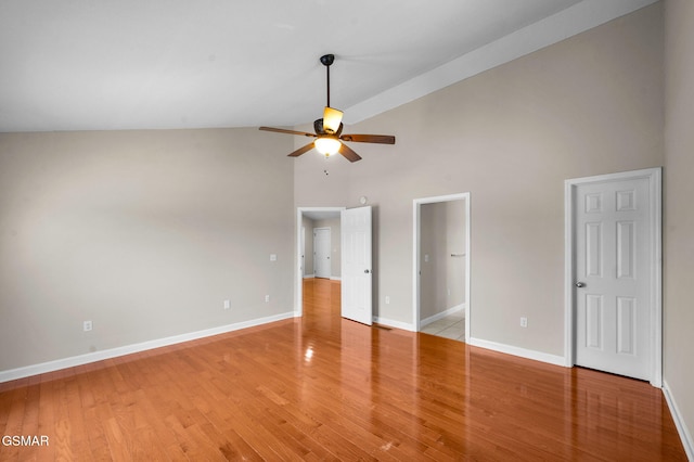 unfurnished bedroom featuring light wood-style floors, baseboards, and high vaulted ceiling