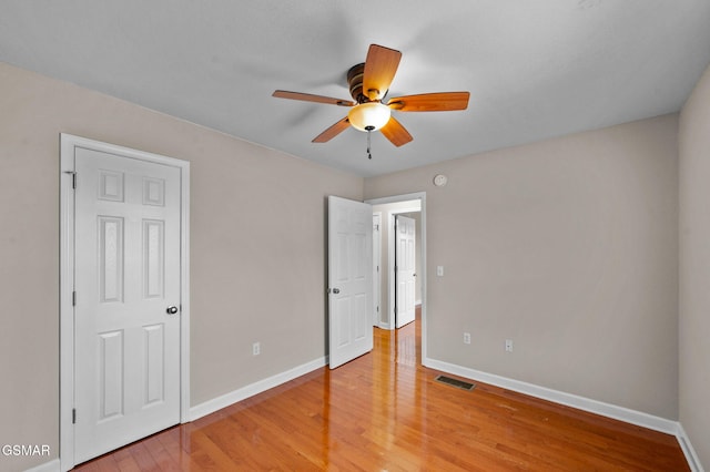 unfurnished bedroom with light wood-type flooring, visible vents, baseboards, and a ceiling fan