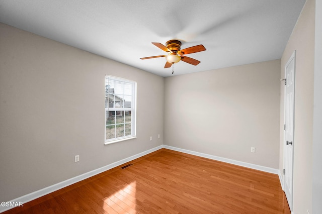 spare room featuring visible vents, a ceiling fan, light wood-type flooring, and baseboards