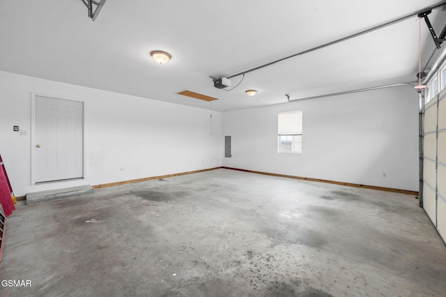 garage featuring electric panel, a garage door opener, and baseboards