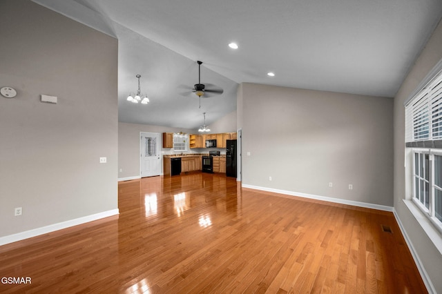 unfurnished living room with visible vents, baseboards, light wood-style flooring, ceiling fan with notable chandelier, and high vaulted ceiling