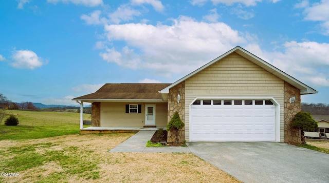 single story home with a porch, concrete driveway, a front yard, a garage, and stone siding