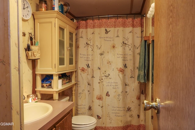 full bathroom featuring a shower with shower curtain, vanity, and toilet