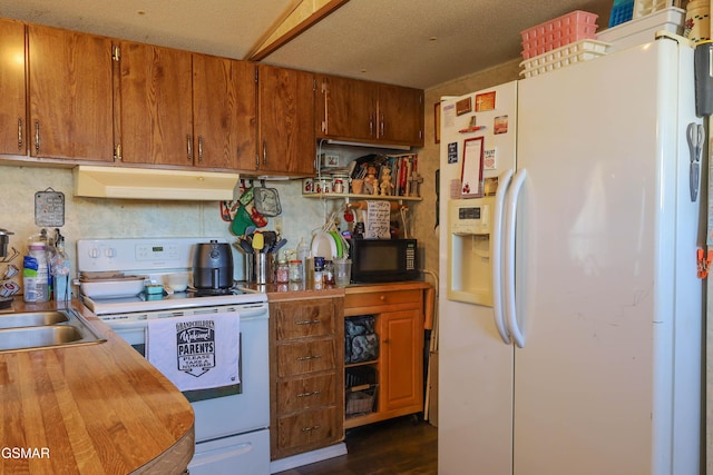 kitchen with white appliances, brown cabinetry, dark wood-style floors, light countertops, and under cabinet range hood