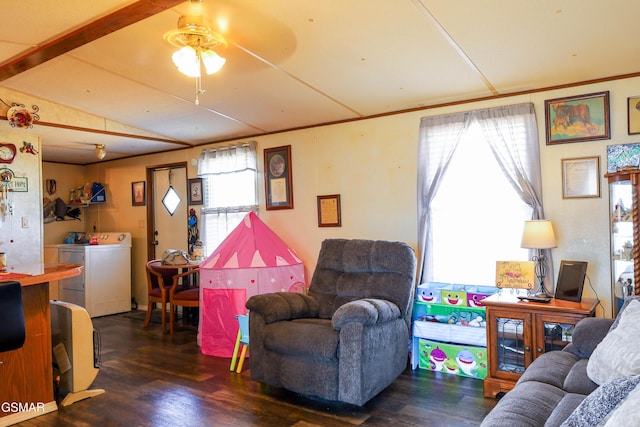 living room featuring dark wood-style floors, vaulted ceiling, ornamental molding, and washing machine and clothes dryer