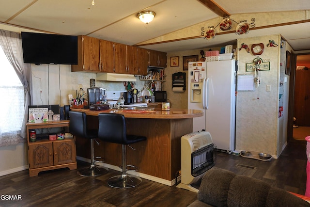 kitchen featuring white fridge with ice dispenser, under cabinet range hood, heating unit, and dark wood-style floors