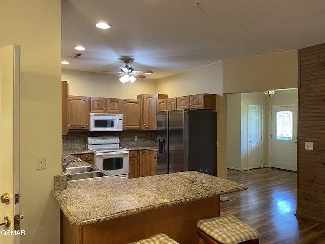 3351 Line Springs Rd, Sevierville, TN 37862 - kitchen with white appliances, dark wood-style flooring, a breakfast bar, ceiling fan, and backsplash