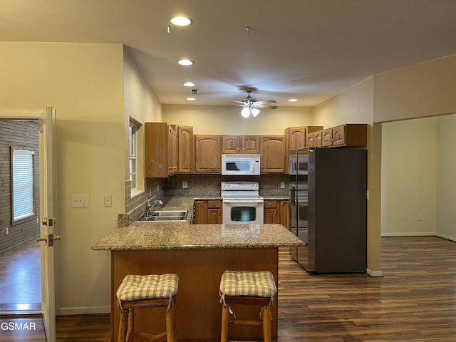 3351 Line Springs Rd, Sevierville, TN 37862 - kitchen with white appliances, a peninsula, dark wood-type flooring, backsplash, and ceiling fan
