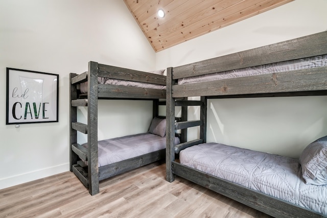 bedroom with wood finished floors, lofted ceiling, wood ceiling, and baseboards