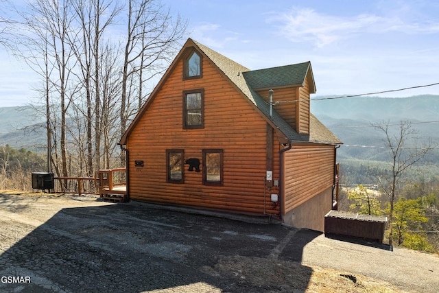 view of side of home with a deck with mountain view