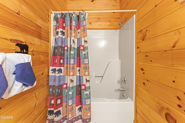 bathroom featuring shower / tub combo with curtain and wooden walls