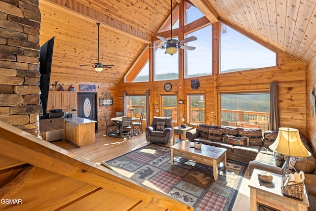 living room with ceiling fan, light wood-type flooring, wooden ceiling, and wooden walls