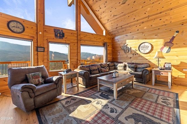 living room with wood ceiling, a mountain view, hardwood / wood-style flooring, and wood walls