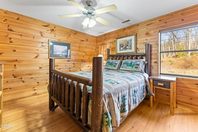 bedroom featuring wood walls and light wood-type flooring