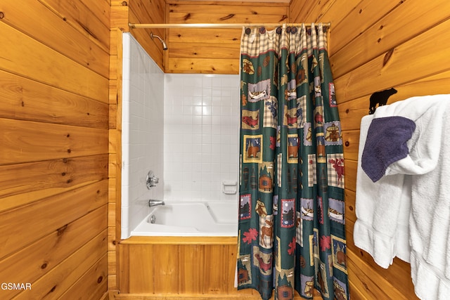 bathroom featuring wooden walls and shower / tub combo