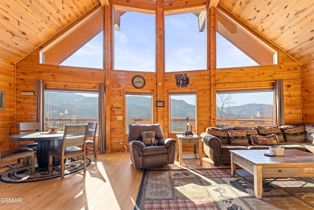 living room featuring wooden walls, a mountain view, and wooden ceiling