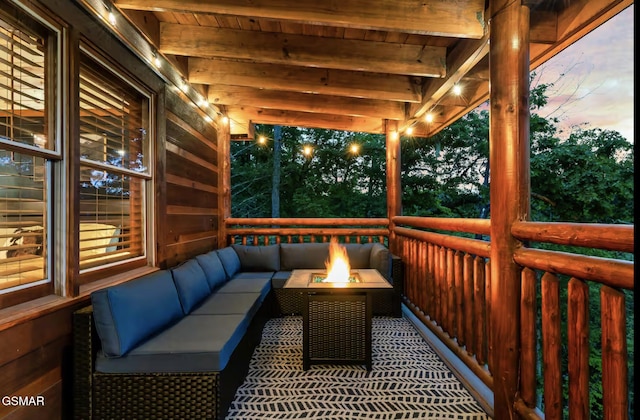 deck at dusk with an outdoor living space with a fire pit