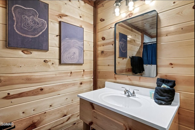 full bathroom with vanity and wood walls