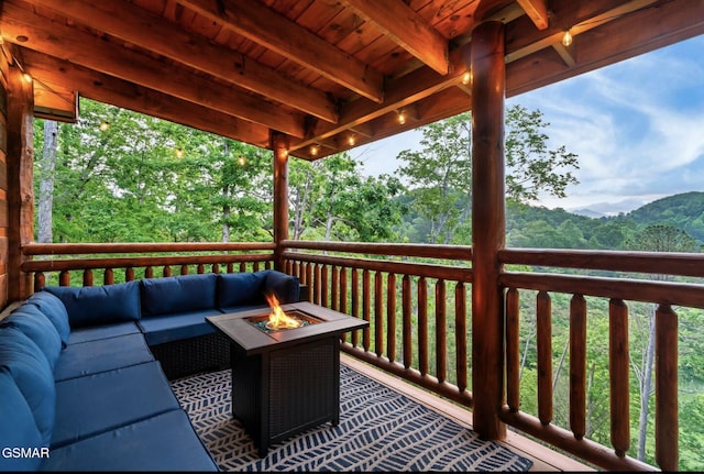 wooden terrace with an outdoor living space with a fire pit