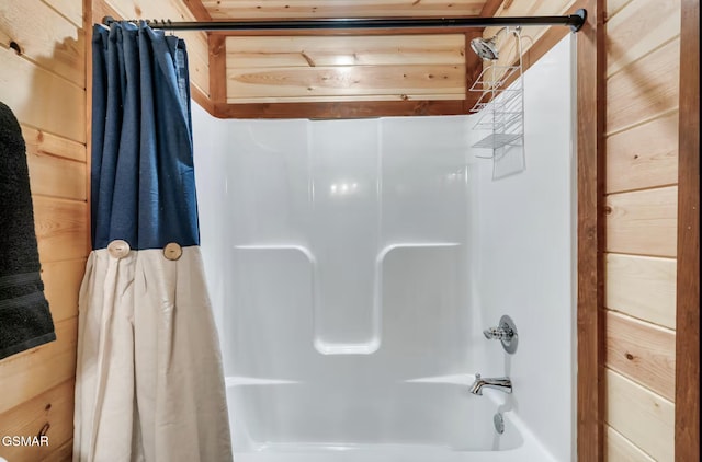 full bathroom with wooden walls and shower / bath combo