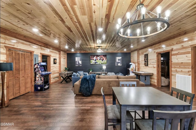 dining space featuring wood walls, wooden ceiling, an inviting chandelier, and wood finished floors