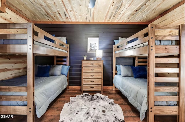 bedroom with wooden ceiling, wooden walls, and dark wood-style flooring