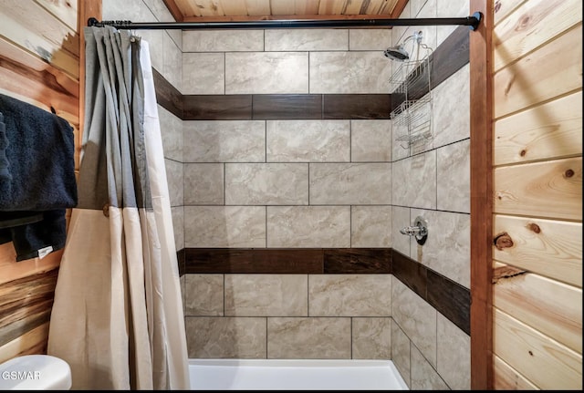 full bathroom featuring a tile shower and toilet