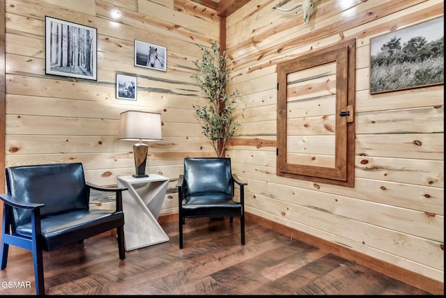 living area with wood finished floors and wood walls