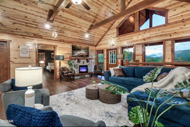 living room with a wealth of natural light, beamed ceiling, wooden walls, and wooden ceiling