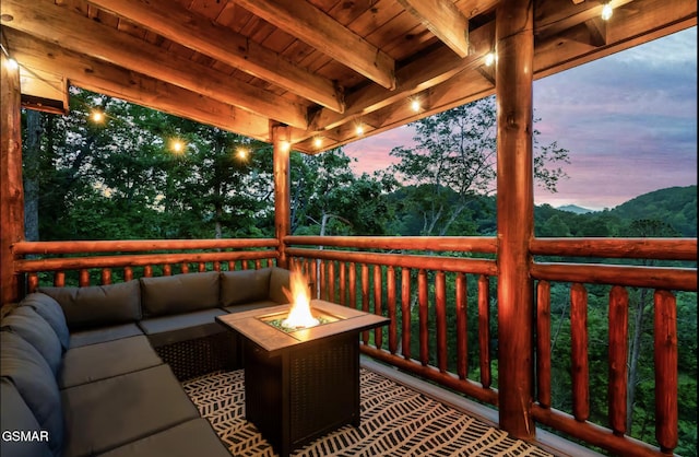 wooden deck with an outdoor living space with a fire pit