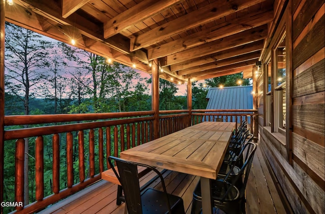 deck at dusk featuring outdoor dining space