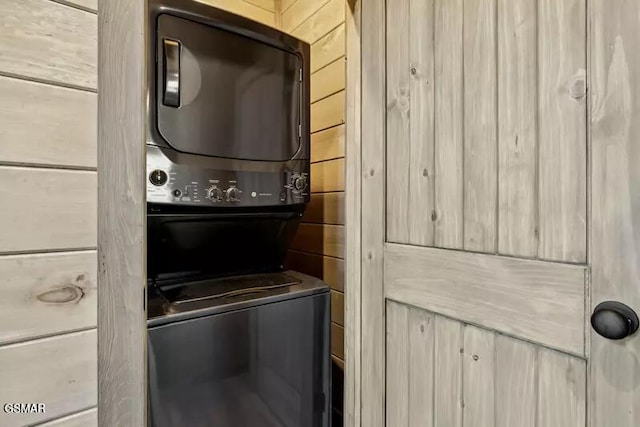 clothes washing area with stacked washer and clothes dryer
