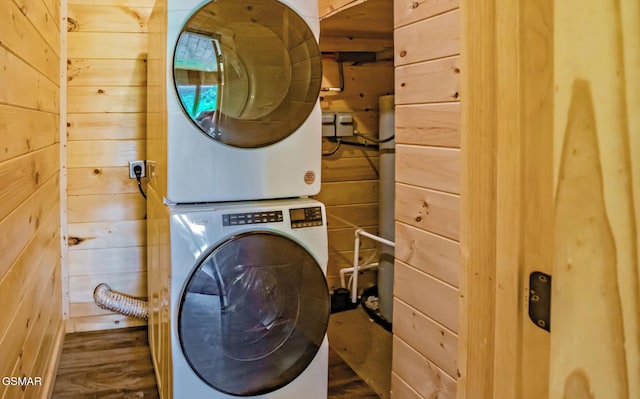 washroom with wooden walls and stacked washing maching and dryer