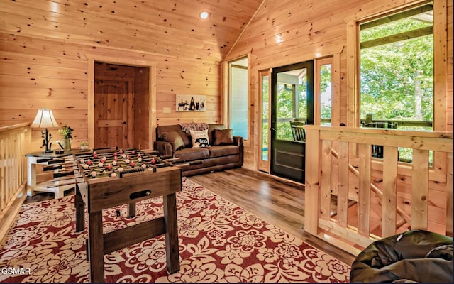 rec room with lofted ceiling, wooden ceiling, light wood-type flooring, and wood walls