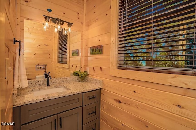 bathroom featuring vanity and wood walls