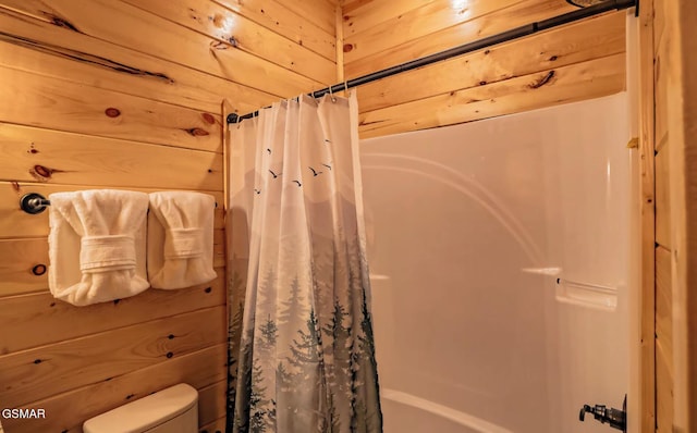 bathroom with toilet and wood walls